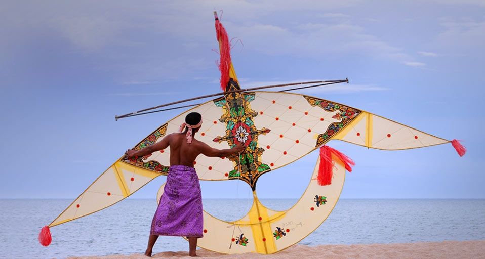 A Malaysian man holds a traditional handmade kite