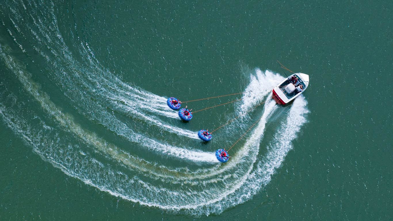 Bateau tractant quatre bouées sur les eaux d’Abbey Lake dans le Surrey, Angleterre