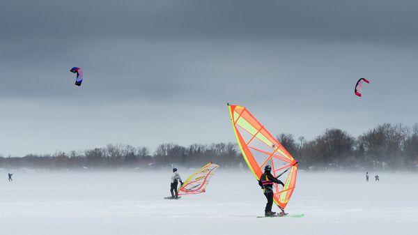 Wind surfers and snow kiters on frozen lake in Keswick, Ontario