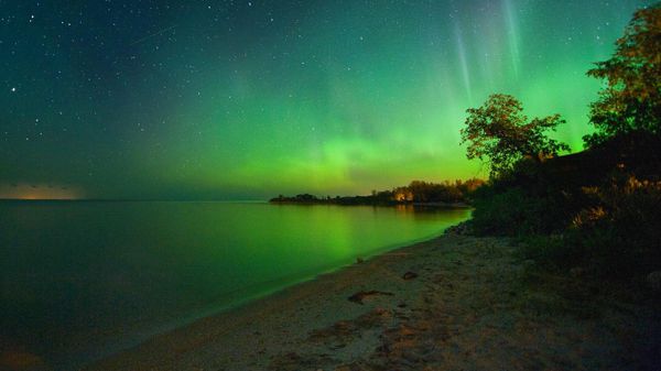 An aurora borealis shines over Laurentian Beach, on the eastern shore of Lake Manitoba