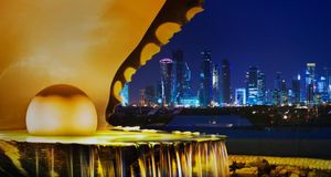 The pearl monument in the Corniche neighborhood of Doha, Qatar, illuminated at night with the new high-rises of West Bay in the background -- Jon Hicks/Corbis &copy; (Bing New Zealand)