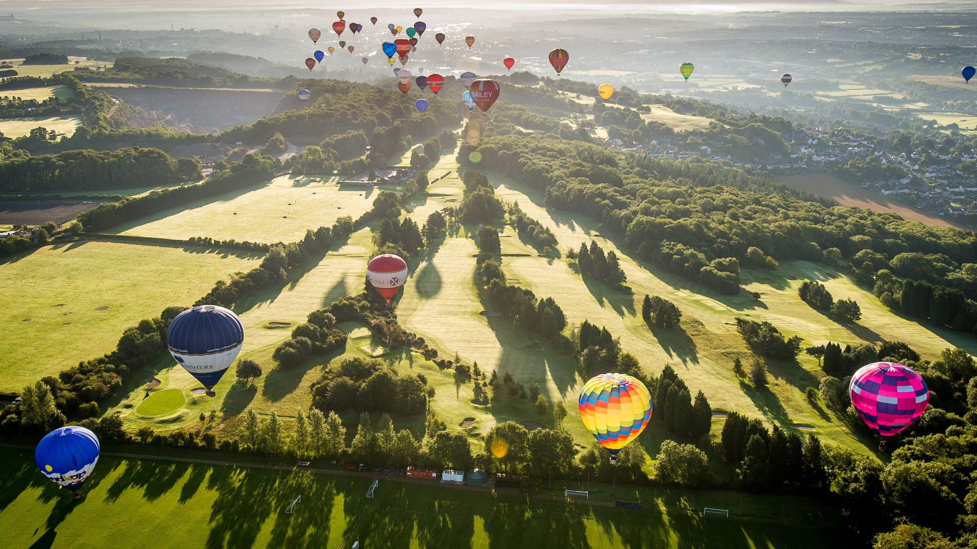 Hot air balloons over a golf course during the Bristol International Balloon Fiesta