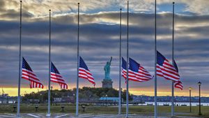 Statue of Liberty seen behind US flags at half-staff for the anniversary of September 11 in 2014, New York City (© Adam Parent/Shutterstock)(Bing United States)
