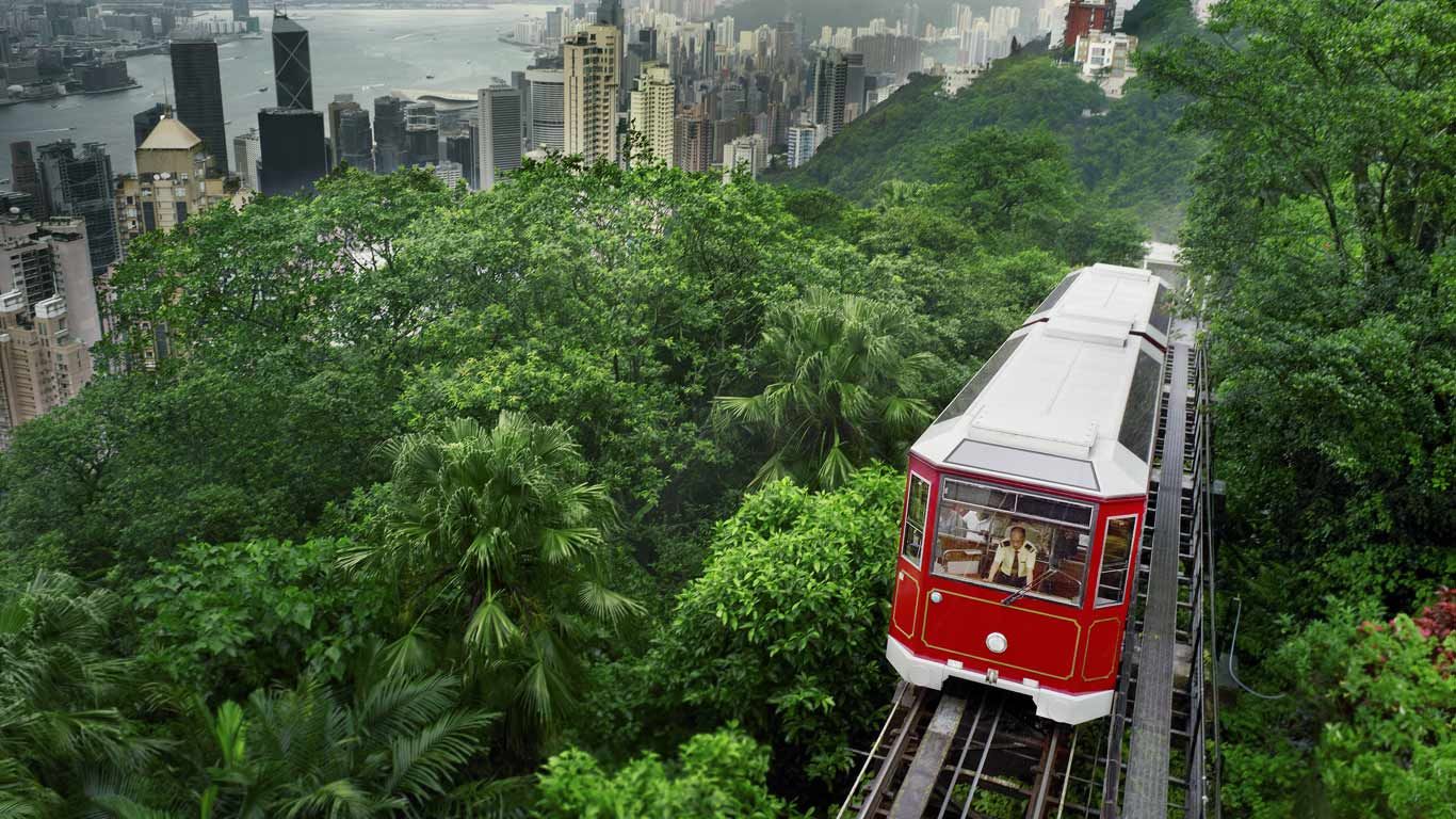 View of the funicular Peak Tramway climbing Victoria Peak, with the city of Hong Kong in the background