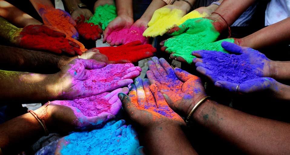 People holding powder paints to celebrate Holi (Festival of Colors) in Ahmedabad, India