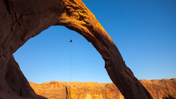 A man rappels off Corona Arch near Moab, Utah, United States