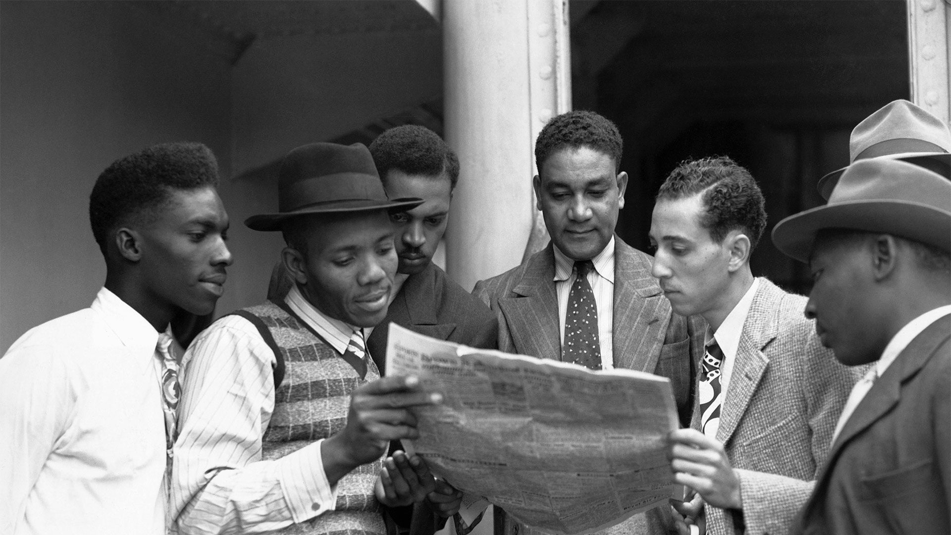 Reading the news aboard the Empire Windrush on arrival at Tilbury, Essex on 22 June 1948