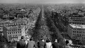Groupe regardant l’avenue des Champs-Élysées noire de monde, depuis le haut de l’Arc de Triomphe, le 8 mai 1945, Paris, France (© AFP via Getty Images)(Bing France)
