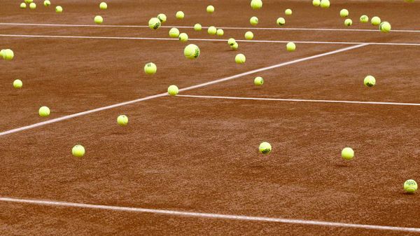 Balles de tennis oubliées sur un terrain en terre battue de Roland Garros