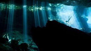 墨西哥艾库玛尔附近，水中岩洞内的潜水者 (© Paul Nicklen/Getty Images)(Bing China)