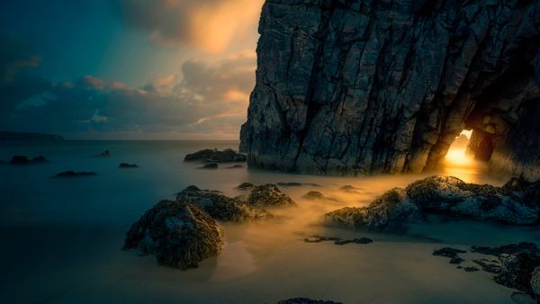 Light from sunrise through a sea cave on the Isle of Skye, Scotland