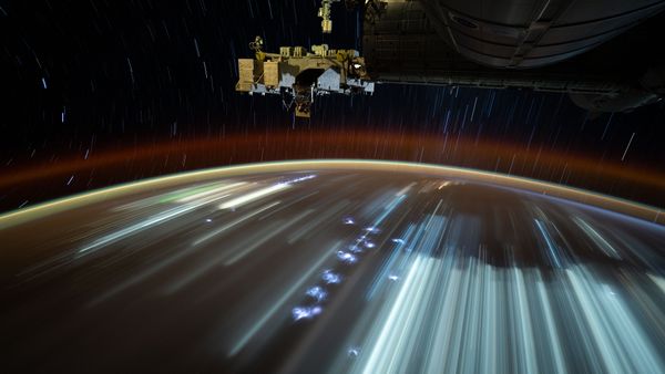 City lights streak below, taken from the International Space Station