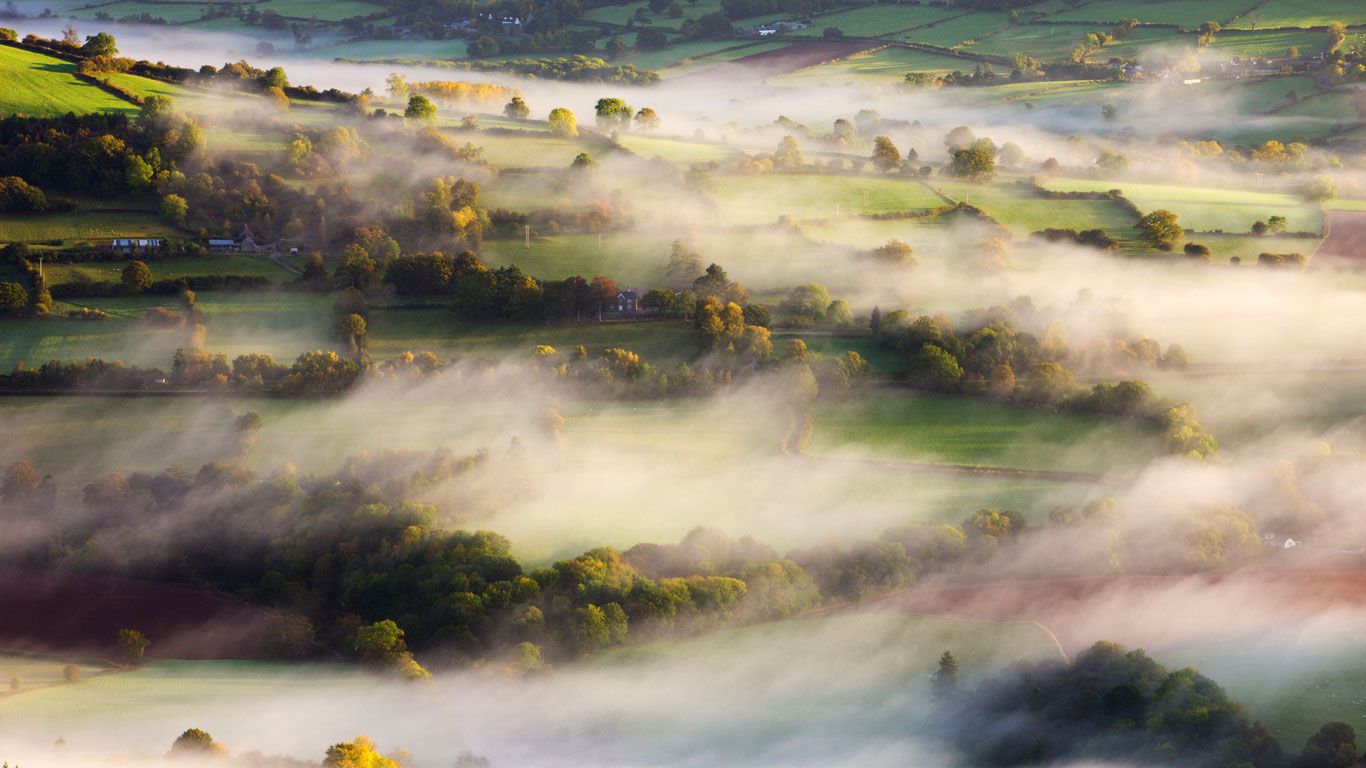 Mist blows over rolling countryside near Talybont-on-Usk in Brecon Beacons National Park, Wales