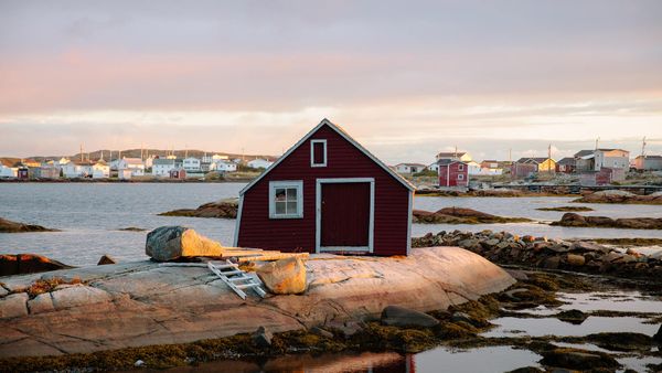 Small red house on the rocky coast of St. John\'s, Newfoundland and Labrador