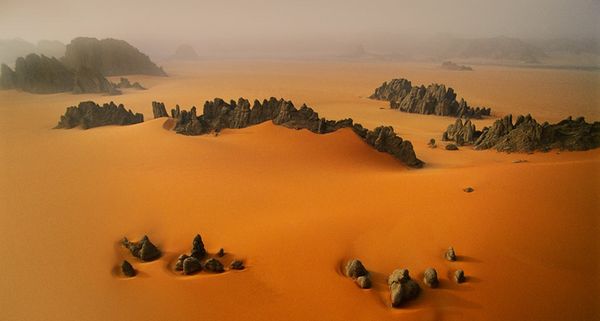Pinnacles of sandstone among orange dunes of the Karnasai Valley, Chad