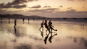一群男孩儿在日落时分的沙滩上踢足球， 巴西福塔雷萨 (© National Geographic/Offset/Shutterstock)(Bing China)