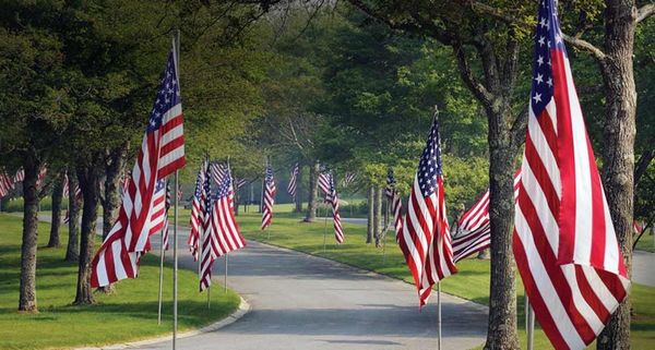 Flags line the entrance of the Massachusetts National Cemetery in Bourne, Cape Cod, Massachusetts