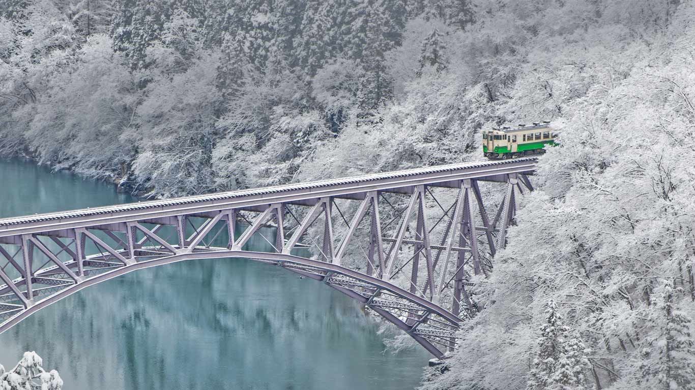 Train crossing the Tadami River near the village of Mishima in Japan