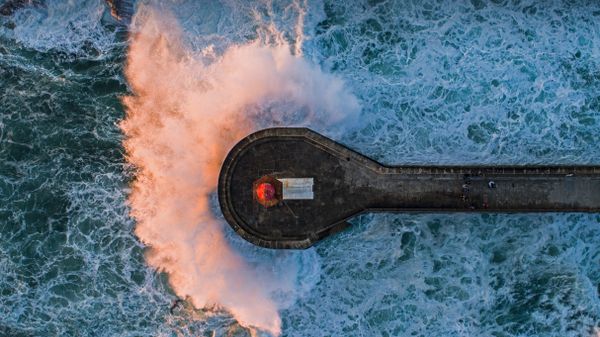Wave crashing on Farolim de Felgueiras, a lighthouse in Porto, Portugal