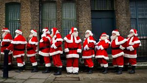 Acteurs habillés en père Noël devant le ministère du fun du père Noël, Londres, Angleterre (© Matt Dunham/AP Photo)(Bing France)