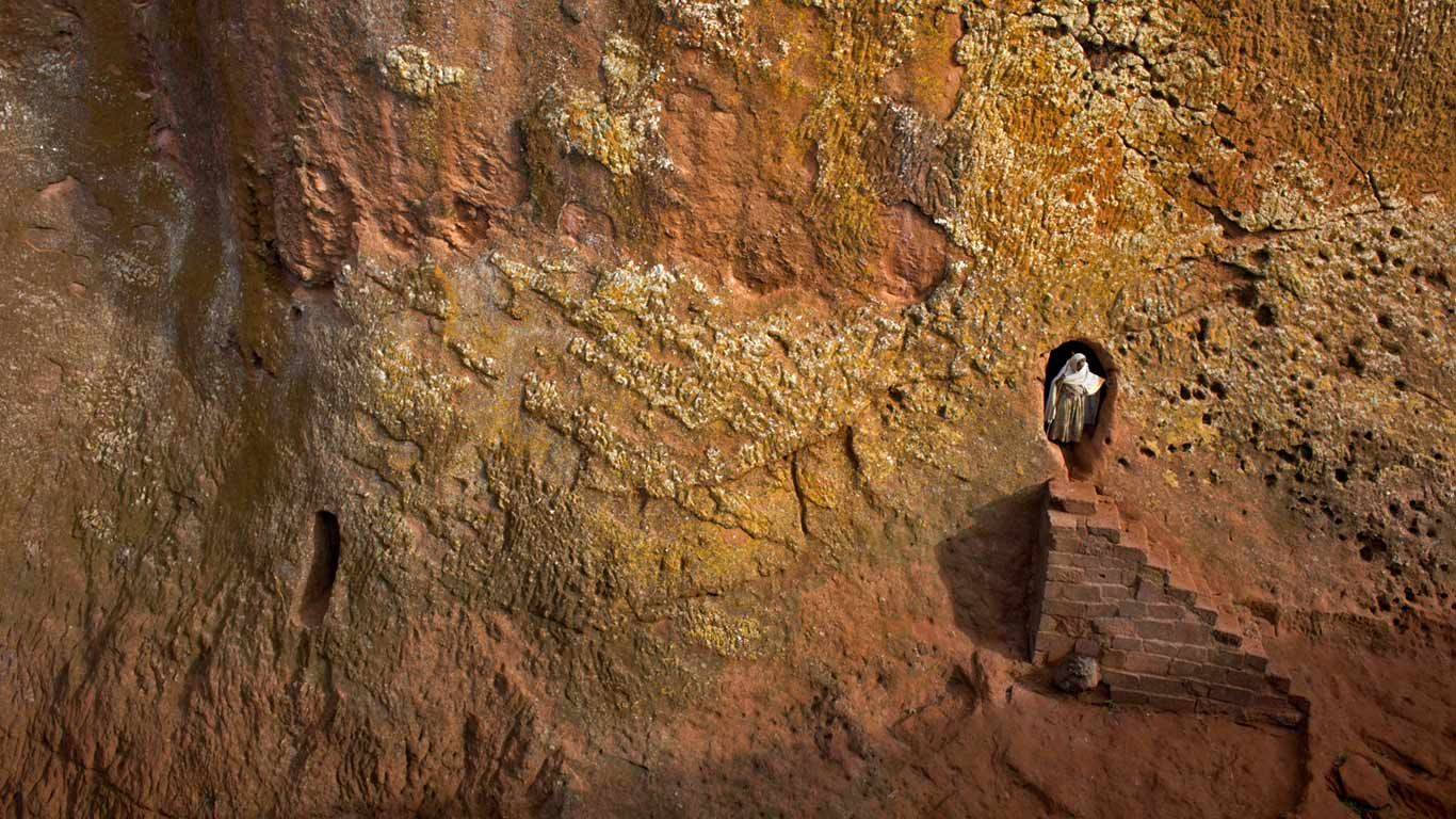 Woman emerges from a tunnel leading to Bet Amanuel, in Lalibela, Ethiopia