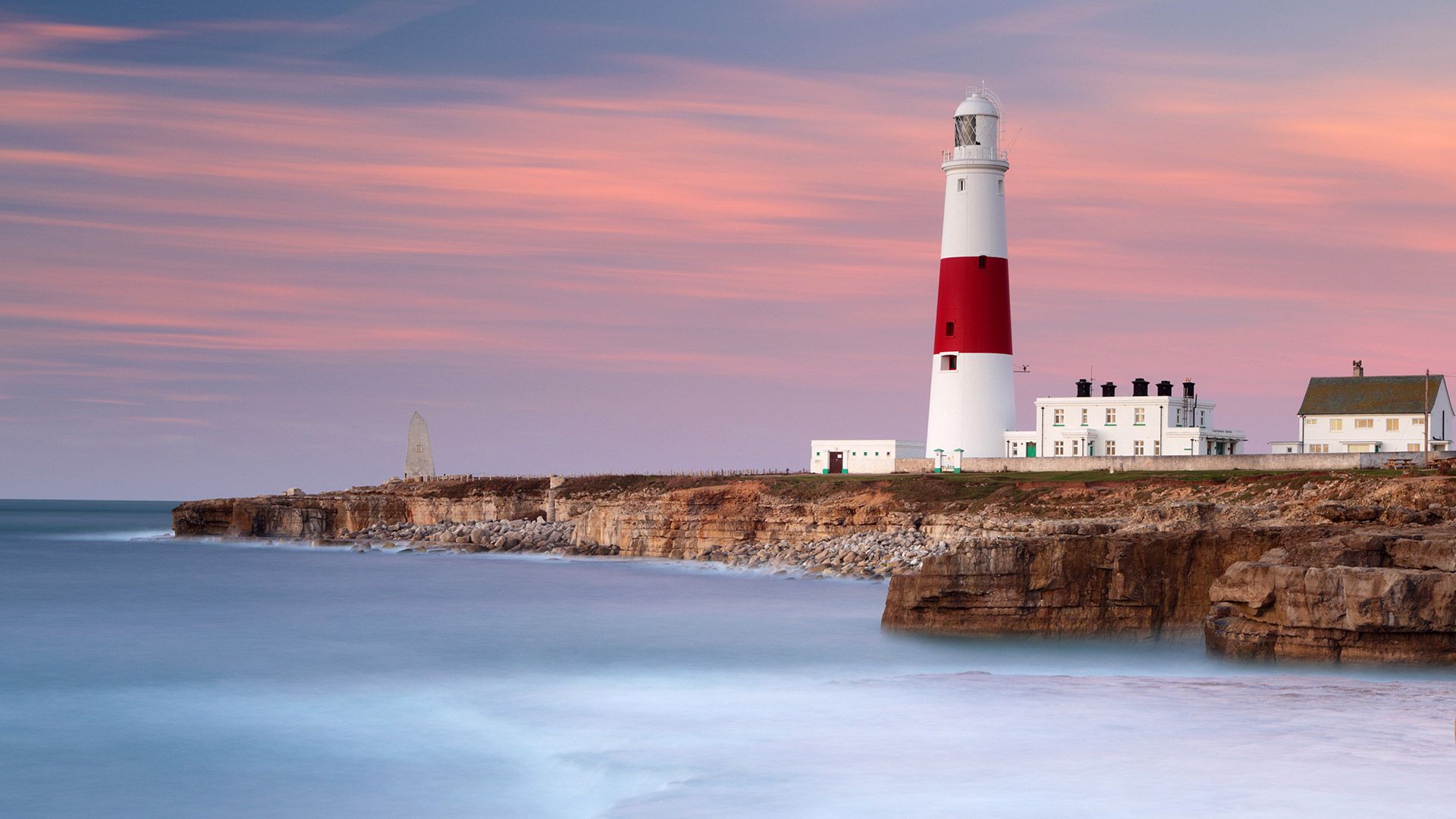Dawn sunlight and waves at Portland Bill lighthouse, Dorset