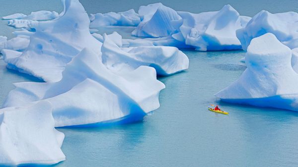 A kayaker crosses Grey Lake in Torres del Paine National Park, Chile