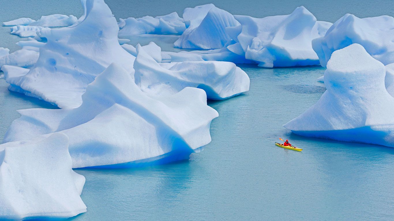 A kayaker crosses Grey Lake in Torres del Paine National Park, Chile