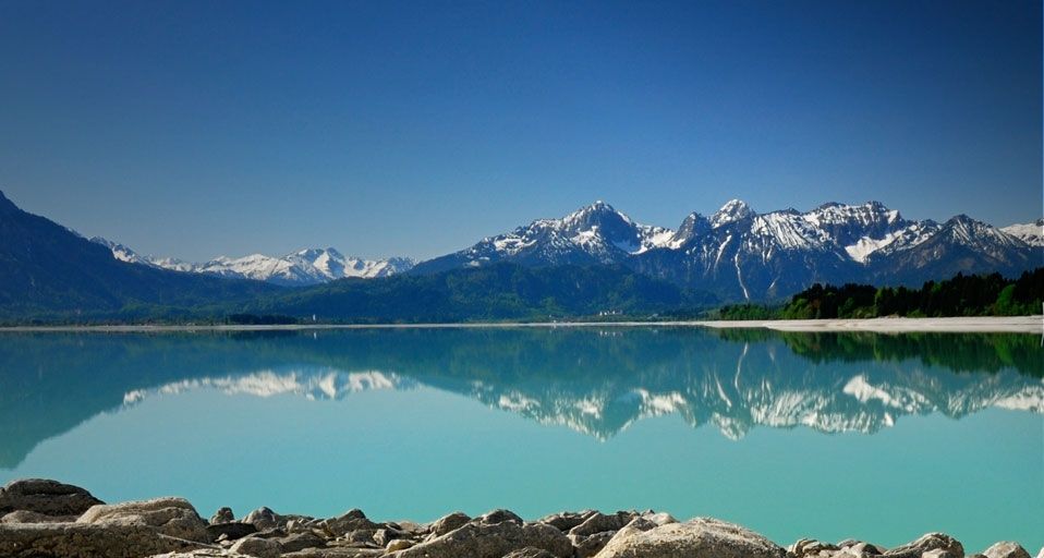 Die Allgäuer Alpen spiegeln sich im Forggensee