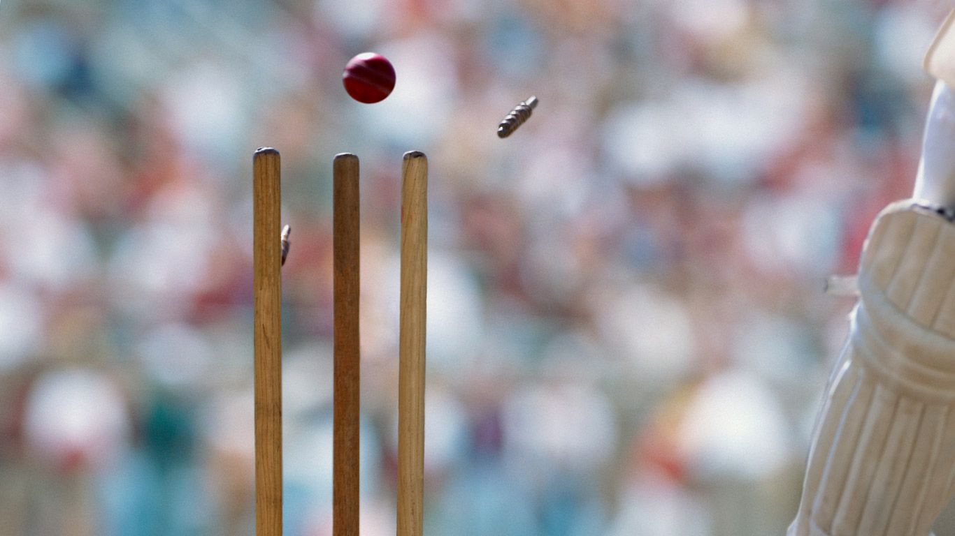 A cricket ball striking the wicket