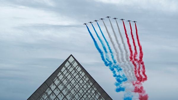 La Patrouille de France au-dessus de la pyramide du Louvre pendant la cérémonie du 14 juillet, Paris