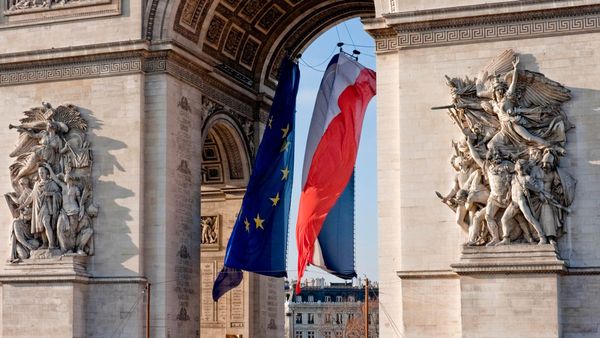 Drapeaux de la France et de l’Europe flottant sous l’Arc de Triomphe, Paris