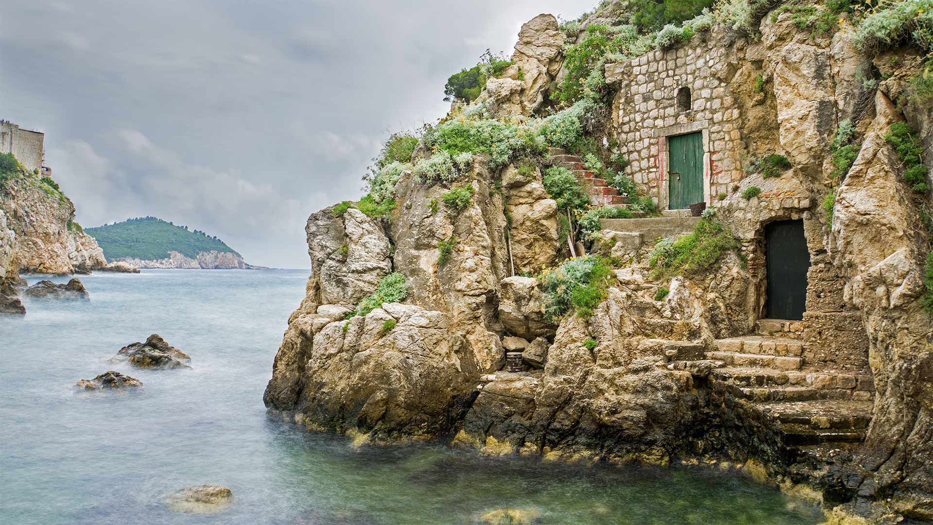 Wooden doors and a stone path at the base of Fort Lovrijenac in Kolorina Bay, Dubrovnik