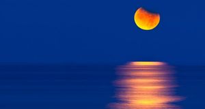 Partial eclipse of the moon setting over the Gulf of Mexico, USA (© David Nunuk/Corbis) &copy; (Bing Australia)