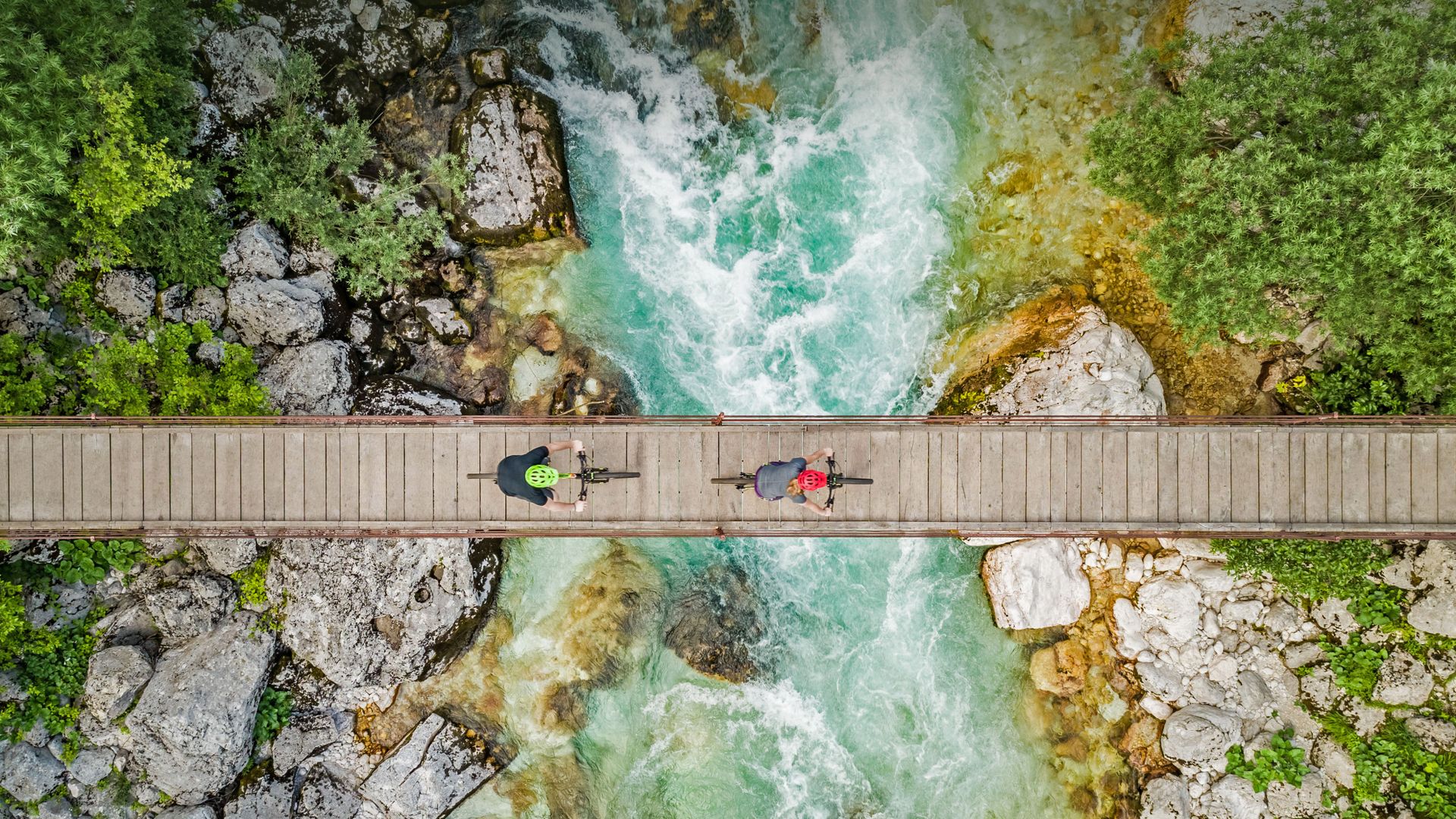 Cyclists on a wooden bridge over the river Soča, Triglav National Park, Slovenia