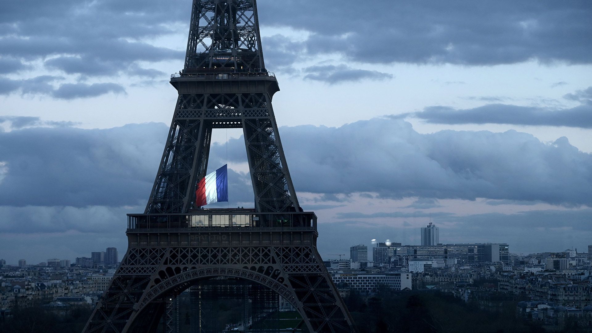 Le drapeau français flottant au centre de la Tour Eiffel, le 11 mars 2020, lors d’une cérémonie pour la première Journée nationale d’hommage aux victimes du terrorisme