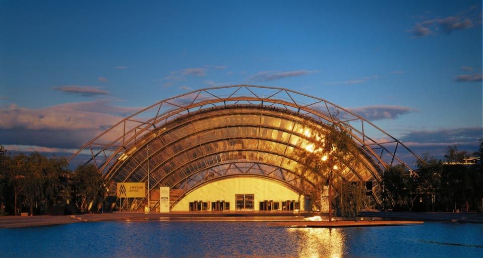 Die Glashalle der Messe Leipzig leuchtet im Abendlicht, Sachsen, Deutschland