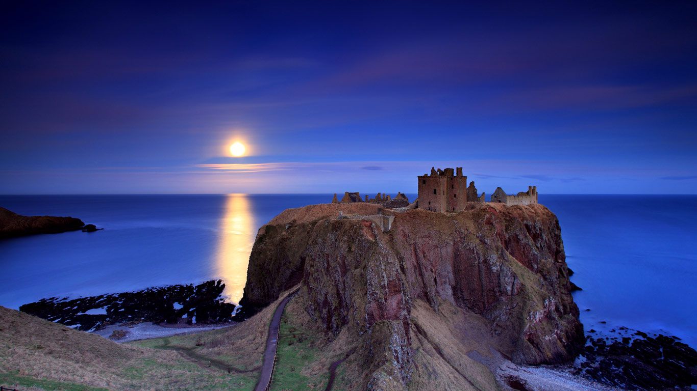 Full moon rising over Dunnottar Castle near Stonehaven on the northeast coast of Scotland