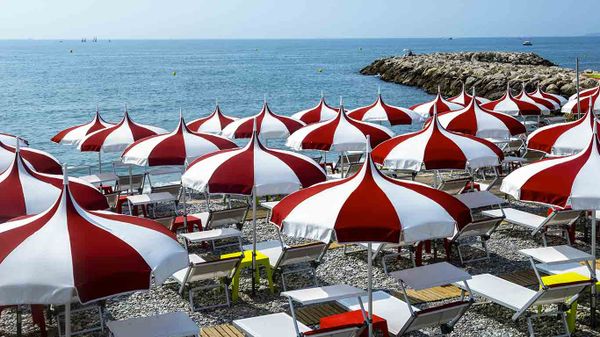 Parasols rouges et blancs sur une plage de Cagnes-sur-Mer, Provence-Alpes-Côte d'Azur, France