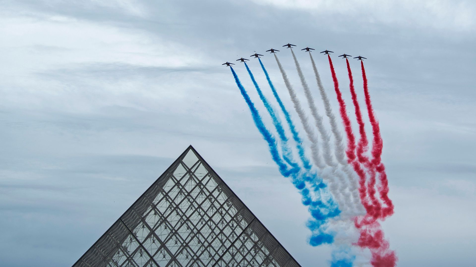 La Patrouille de France au-dessus de la pyramide du Louvre pendant la cérémonie du 14 juillet, Paris