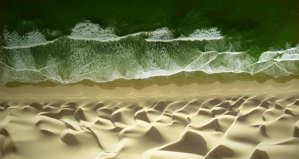 Waves of water meet waves of sand on the beach of the Pacific Ocean near Paracas, Peru