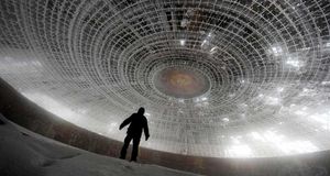 A man walks inside the crumbling skeleton of the House of the Bulgarian Communist Party on Mount Buzludzha, Bulgaria (© Dimitar Dilkoff/Getty Images) &copy; (Bing Australia)
