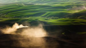 A tractor kicks up dust while tilling fields on the Palouse near Pullman, Washington (© Ben Herndon/Tandem Stills + Motion)(Bing New Zealand)