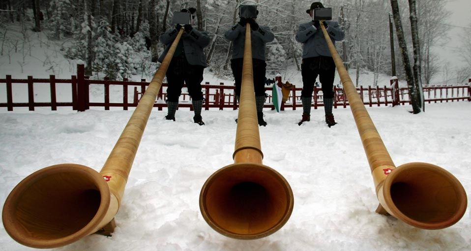 Three alphorn players from the International Alphorn Society perform in Fort Kent, Maine, USA