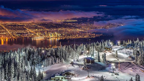 City lights from the snowy peak of Grouse Mountain at twilight, Vancouver, BC, Canada