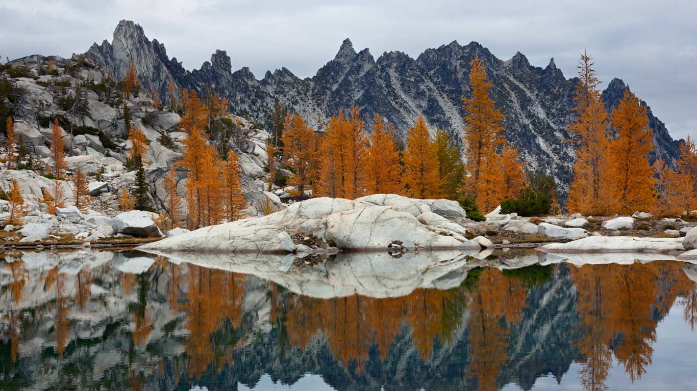 Golden larches and Prusik Peak reflected in Troll Sink Tarn, Upper Enchantments, Alpine Lakes Wilderness, Washington, USA