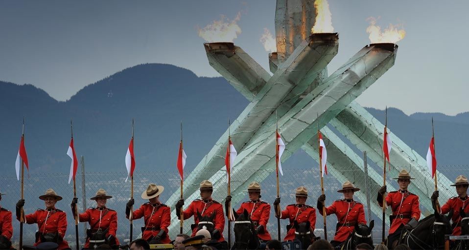 Parade kanadischer Mounties mit ihren Pferden vor dem Olympischen Feuer in Vancouver am 23. Februar 2010