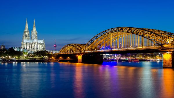 Hohenzollernbrücke mit dem Kölner Dom und dem Rhein bei Sonnenuntergang in Köln