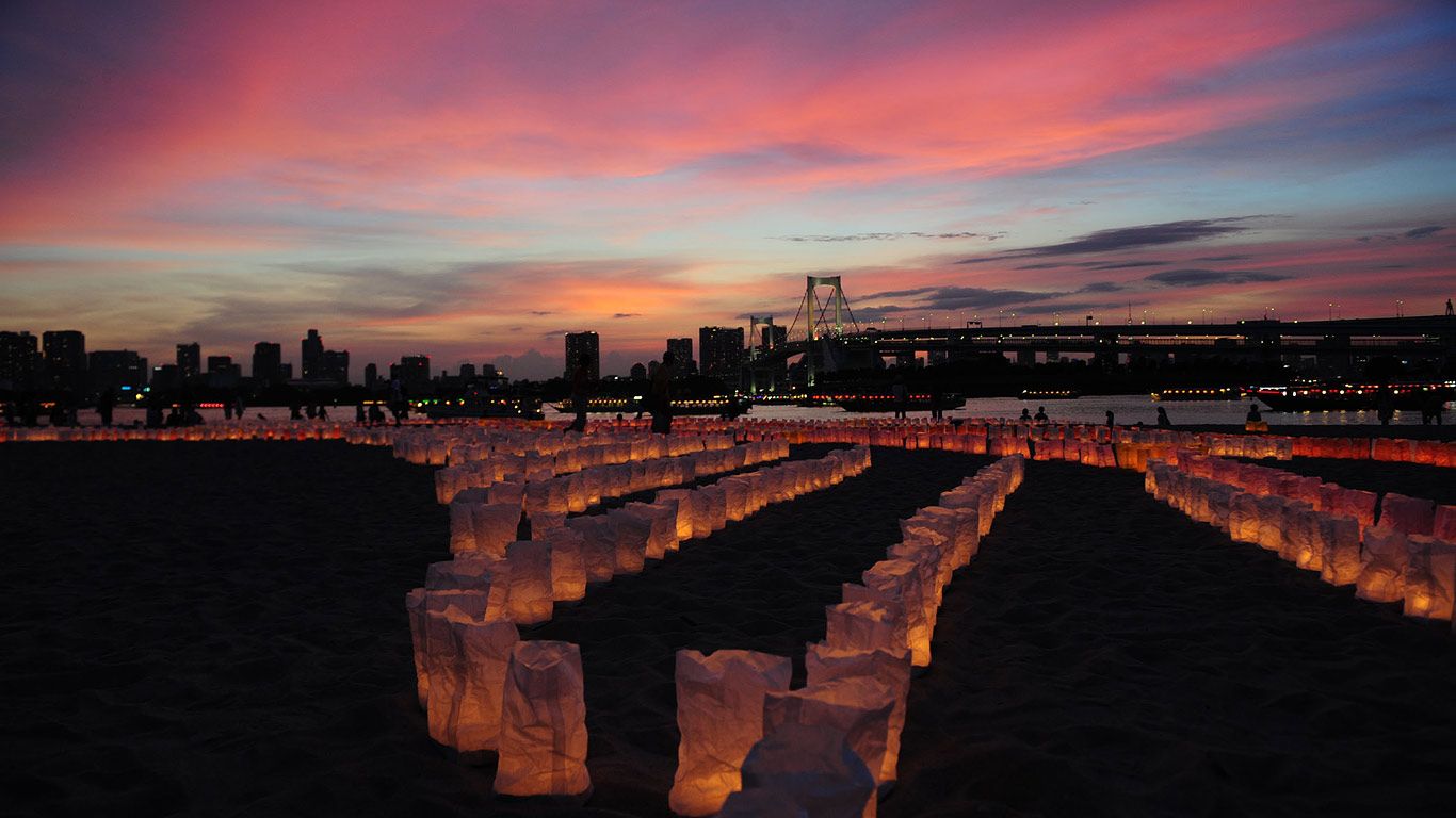 Candles line the beach at Odaiba Marine Park for Marine Day, Tokyo, Japan