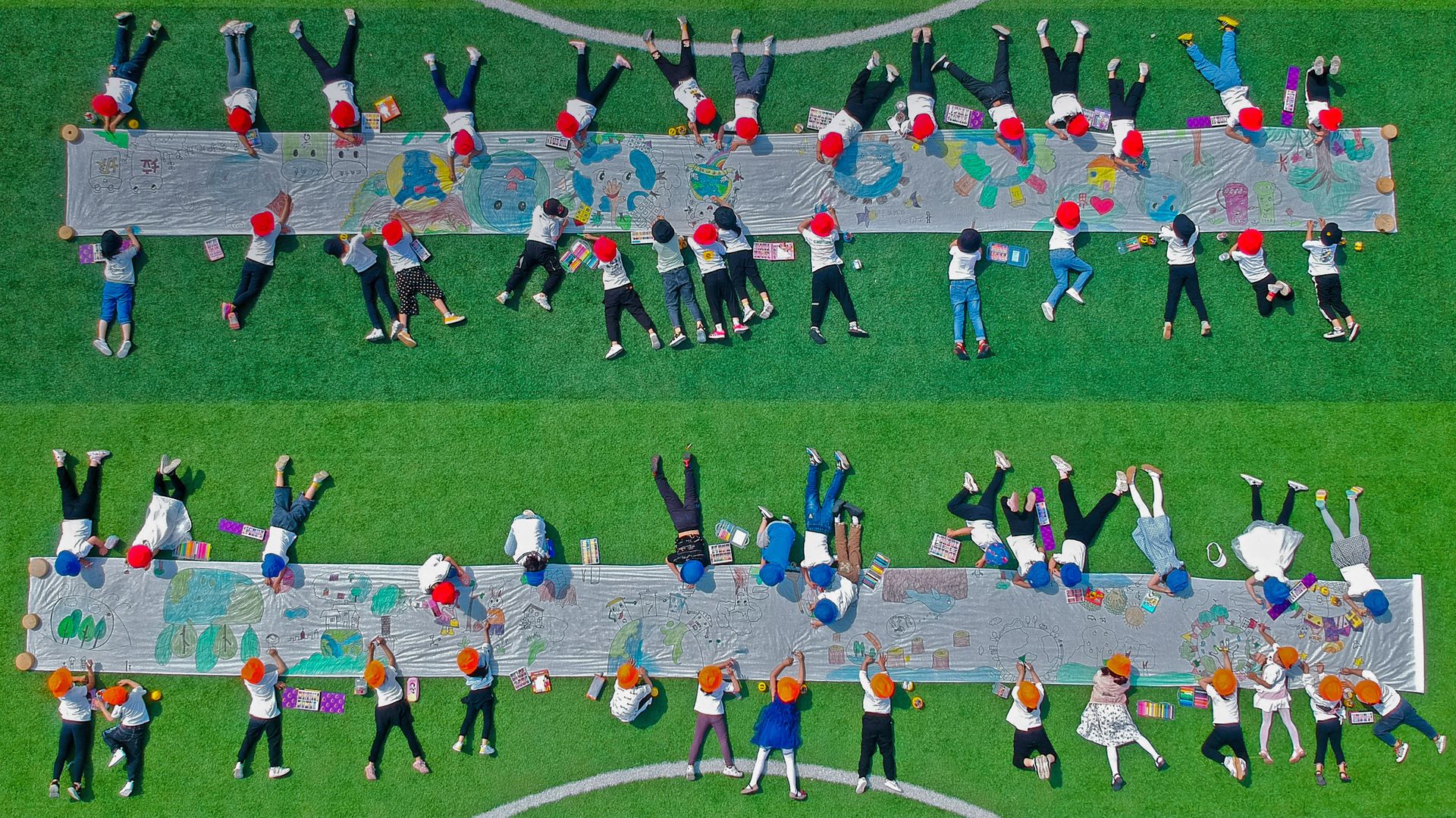 Kindergarteners drawing on canvases in Nantong, Jiangsu province, China